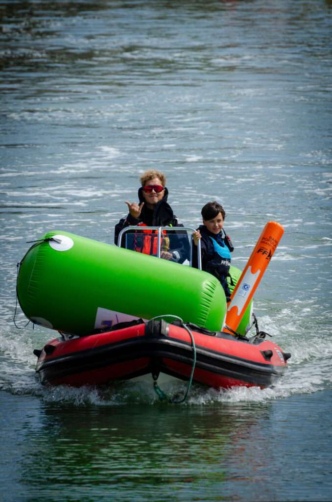 Photo d'un bénévole et d'un moniteur prêt à aller déposer une bouée sur le parcours pour la coupe régionale de voile des Pays de la Loire